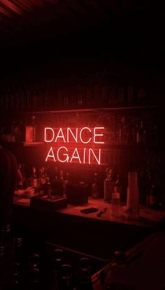 a red neon sign that reads dance again in the middle of a dark room with bottles