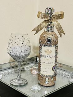 a bottle of wine sitting on top of a table next to a crystal goblet