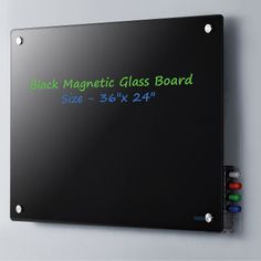 a magnetic glass board mounted to the side of a wall