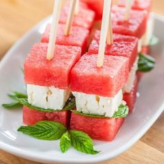 watermelon skewers with mint on a white plate