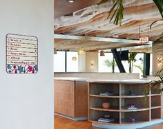 the inside of a building with wooden flooring and large plant in front of it