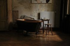 an old fashioned bath tub sitting in the middle of a room next to a table