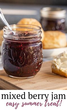 a jar of jam sitting on top of a wooden cutting board next to some bread