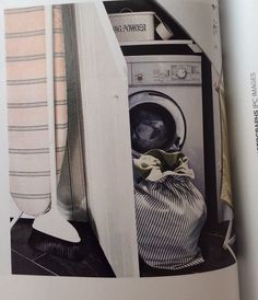 an open magazine showing a washing machine and clothes in the laundry basket with towels on it