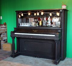 an old piano is sitting in front of a bar