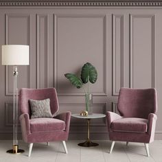 a living room with two chairs and a table in front of a wall that has a plant on it