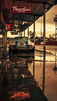 an old car is parked in the rain under a neon sign that reads motorists