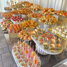 a buffet table filled with lots of different types of desserts and pastries on sticks