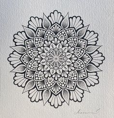 a black and white drawing of a flower on paper with watercolor pencils in it