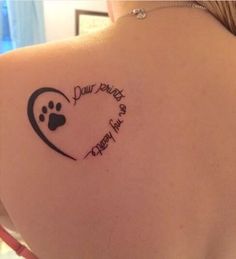 the back of a woman's shoulder with a dog paw and heart tattoo on it