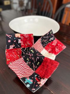 a bowl sitting on top of a wooden table next to a red and white plate