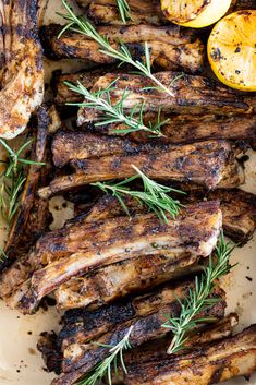 grilled lamb chops with lemon and rosemary garnish on a white platter