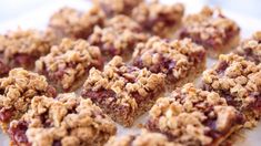 some granola bars are sitting on a white plate with cranberry toppings