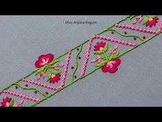 a close up of a piece of cloth with pink flowers on it and green trim