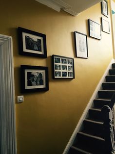 the stairs are lined with black and white photos on the wall, along with framed photographs