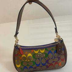 Coach Signature Rainbow Teri Shoulder Bag (Ca176) Khaki Rainbow Signature Coated Canvas. Leather Accents And Detachable Handle. Removable, Adjustable 23.75" Crossbody Strap. Top Zip Closure. Interior Multi-Function Pocket. 9.5" (L) X 6" (H) Coach Rainbow Bag, Rainbow Bag, Leather Accents, Signature Canvas, Strap Top, Canvas Leather, Crossbody Strap, Coach Bags, Multi Color