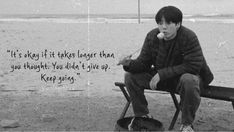 a man sitting on top of a bench next to the ocean with a quote about it