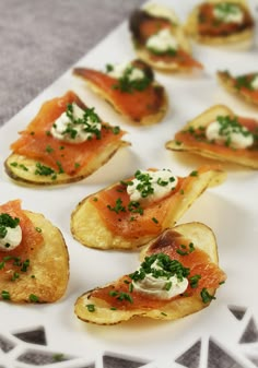 small appetizers with salmon and cream cheese on them sit on a white plate