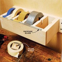 several rolls of tape are stored in a drawer on the floor next to an electrical outlet