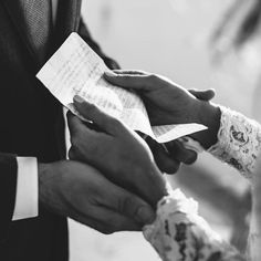 the bride and groom are holding each other's hands as they hold their wedding vows