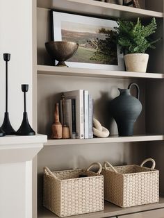 the shelves are filled with vases, books and other decorative items in baskets on them