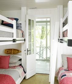 two bunk beds with red and white bedding next to each other in a room