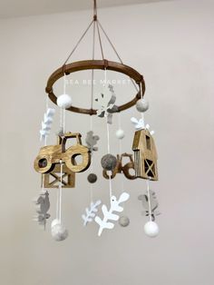 a mobile made out of wood and paper with farm animals hanging from it's sides