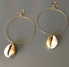 The cowrie shell once utilized as exchange currency, is revered as a symbol of fertility, goddess protection, wealth, and powerful in its connection to the strength of the ocean.  These shells have been hand leafed with gold tone leaf, base metal hoops and ear wires.  Few pairs available as these are custom made to order. Gold Teardrop Jewelry For Beach, Gold Teardrop Jewelry For The Beach, Spiritual Gold Shell-shaped Jewelry, Spiritual Gold Shell Jewelry, Gold Shell-shaped Hoop Earrings For Beach, Gold Shell-shaped Hoop Earrings, Gold Shell-shaped Hoop Earrings For Pierced Ears, Gold Metal Hoop Earrings For Beach, Handmade Gold Hoop Earrings For Beach