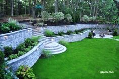 this is an aerial view of a backyard with stone walls and steps leading up to the lawn