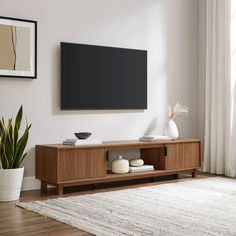 a flat screen tv mounted to the side of a wooden entertainment center in a living room