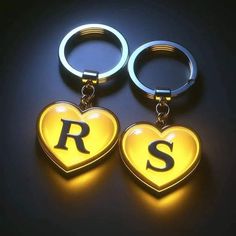 two heart shaped keychains with the letter r on them, sitting next to each other