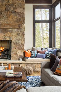 a living room filled with furniture and a fire place in front of a stone fireplace