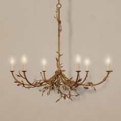 a chandelier made out of branches with lit candles in the middle and one light on each end