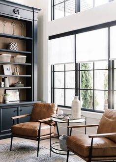 a living room filled with furniture next to a large open bookcase and window sill