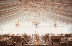 the inside of a wedding tent with tables and chairs set up for an elegant dinner