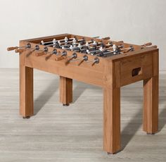 a wooden foosball table sitting on top of a hard wood floor