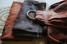 two pieces of cloth on a table with a metal ring