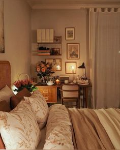 a bedroom with a bed, desk and pictures on the wall