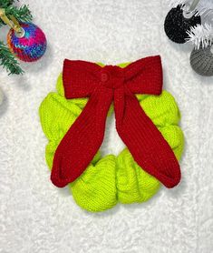 a pair of red and green knitted scrunffles next to christmas ornaments