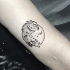 a black and white koala tattoo on the right arm with an animal in it's center