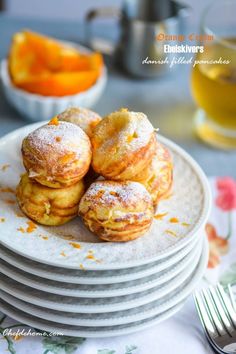 several pastries are stacked on top of each other in front of some oranges