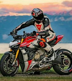 a man riding on the back of a red and white motorcycle