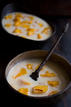 two bowls filled with soup on top of a wooden table