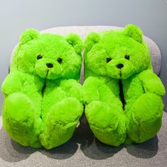 two green teddy bears sitting on a chair