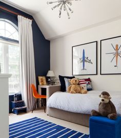 a teddy bear sitting on top of a bed next to two framed pictures above it