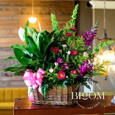 a basket filled with lots of flowers sitting on top of a table