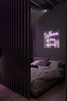 there is a purple light on the wall above the bed