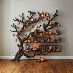 a halloween tree with bookshelves and candles on it in front of a wall