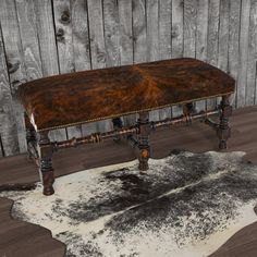 an old bench is sitting on top of a cowhide rug