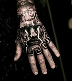 a man's hand with tattoos on it that has lightning coming out of his face